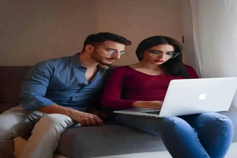 Happy couple shopping online with credit card on laptop